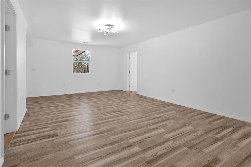 909 East Sears Street Denison, TX 75021 - Photo 11 of 24 Spare room with light wood-type flooring and baseboards