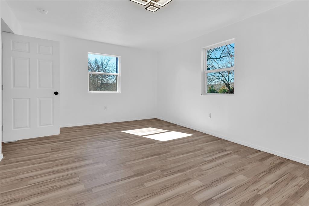 909 East Sears Street Denison, TX 75021 - Photo 12 of 24 Empty room featuring light wood-type flooring