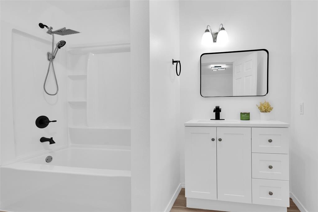 909 East Sears Street Denison, TX 75021 - Photo 14 of 24 Full bath with vanity, bathing tub / shower combination, and light wood-type flooring