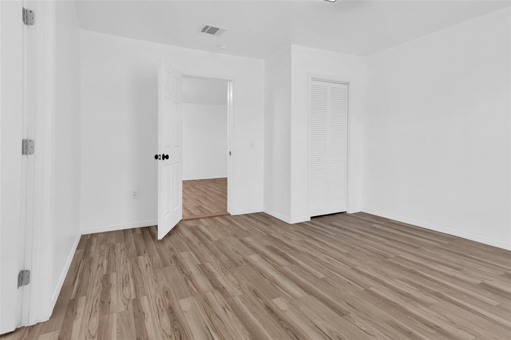 909 East Sears Street Denison, TX 75021 - Photo 15 of 24 Unfurnished bedroom with wood finished floors and a closet