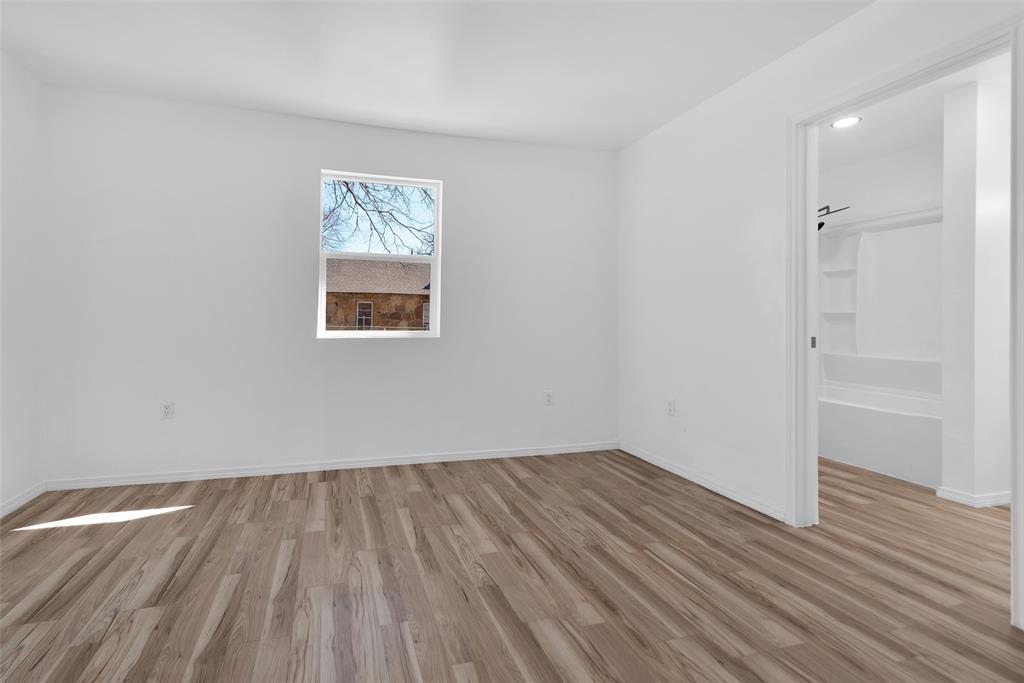 909 East Sears Street Denison, TX 75021 - Photo 16 of 24 Unfurnished room featuring light wood finished floors and baseboards