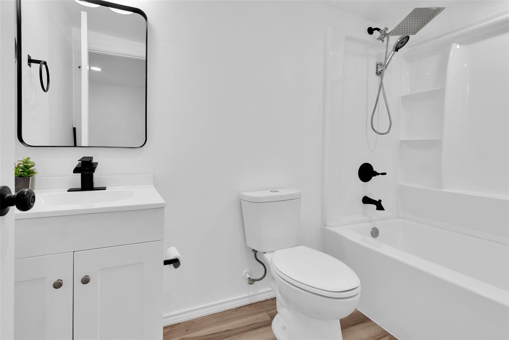 909 East Sears Street Denison, TX 75021 - Photo 18 of 24 Full bath featuring vanity, shower / bath combination, and light wood-type flooring