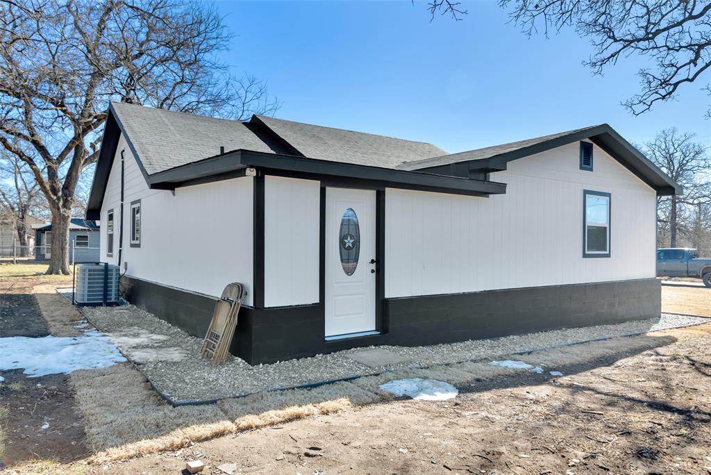 909 East Sears Street Denison, TX 75021 - Photo 20 of 24 View of property exterior with a central air condition unit and roof with shingles