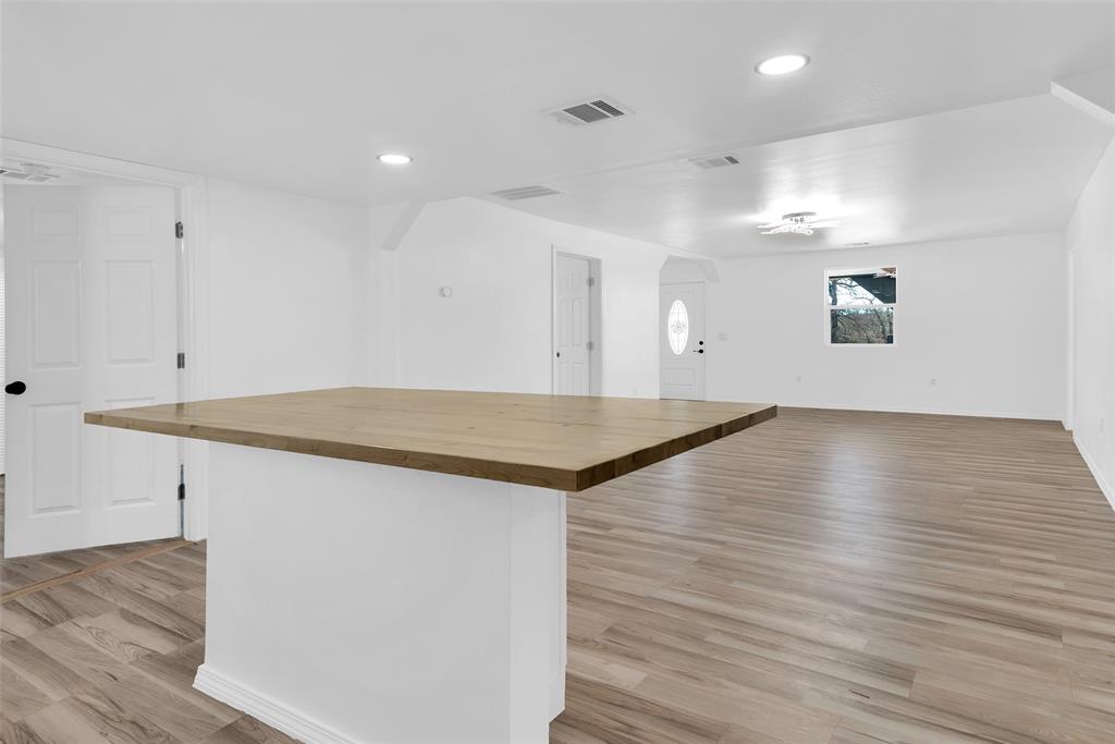 909 East Sears Street Denison, TX 75021 - Photo 24 of 24 Kitchen featuring wooden counters, light wood finished floors, open floor plan, recessed lighting, and a center island