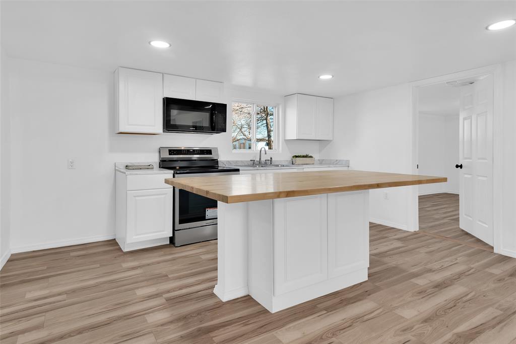 909 East Sears Street Denison, TX 75021 - Photo 5 of 24 Kitchen featuring wood counters, electric stove, a kitchen island, white cabinetry, and recessed lighting