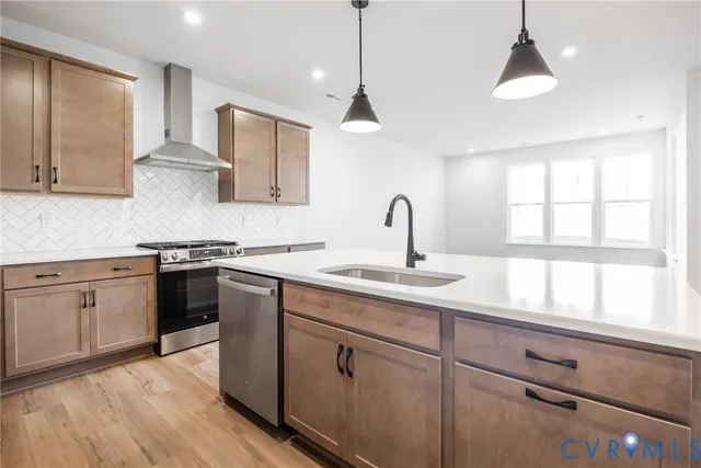 a kitchen with a sink a counter top space stainless steel appliances and cabinets