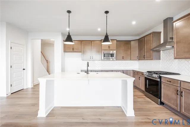 a view of a kitchen with kitchen island a sink wooden floor and a large window
