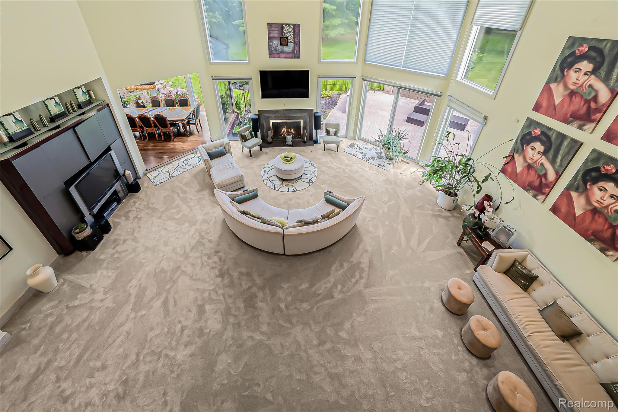 2785 Cranbrook Ridge Court Rochester, MI 48306 - Photo 66 of 99 Spacious living area featuring a fireplace with stone surround, two-story windows with integrated blinds, and multiple sliding glass doors for outdoor access