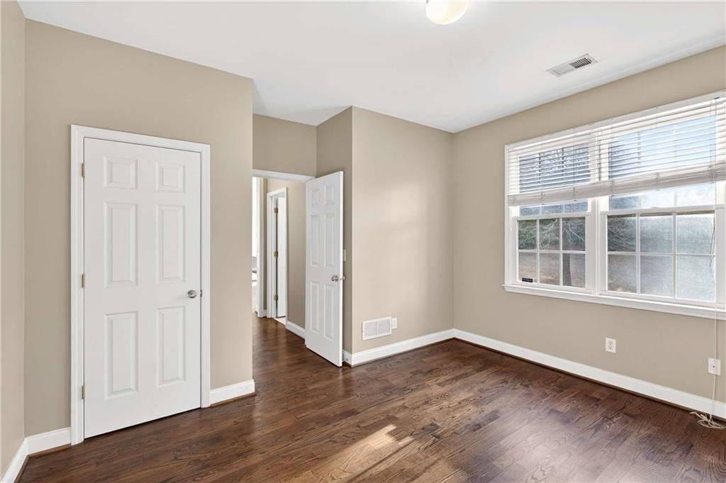 5731 Vinings Retreat Way Southwest Mableton, GA 30126 - Photo 12 of 32 a view of an empty room with wooden floor and a window