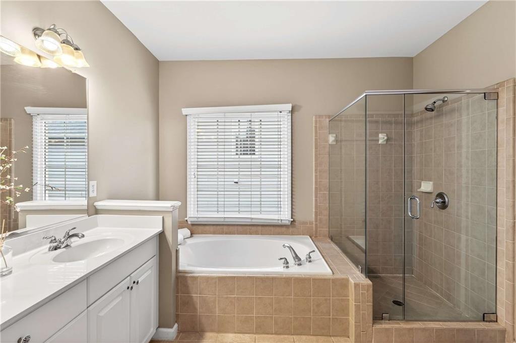5731 Vinings Retreat Way Southwest Mableton, GA 30126 - Photo 17 of 32 a bathroom with a tub a sink and a shower