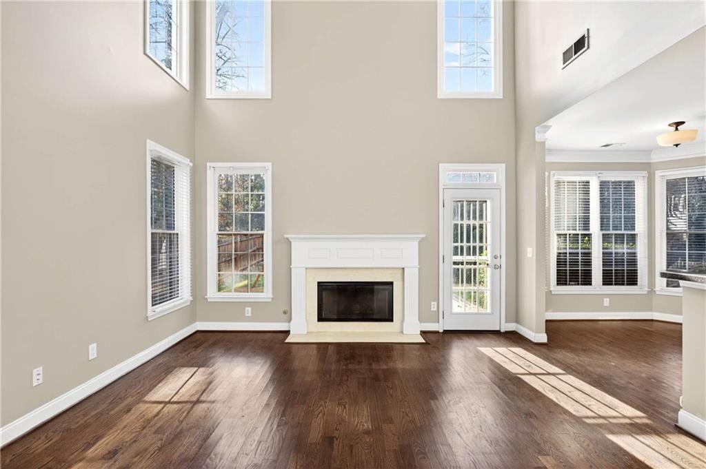 5731 Vinings Retreat Way Southwest Mableton, GA 30126 - Photo 5 of 32 an empty room with wooden floor fireplace and windows
