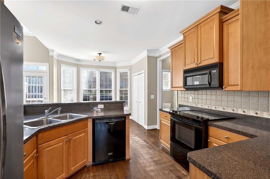 5731 Vinings Retreat Way Southwest Mableton, GA 30126 - Photo 6 of 32 a kitchen with stainless steel appliances granite countertop a stove a sink and a microwave
