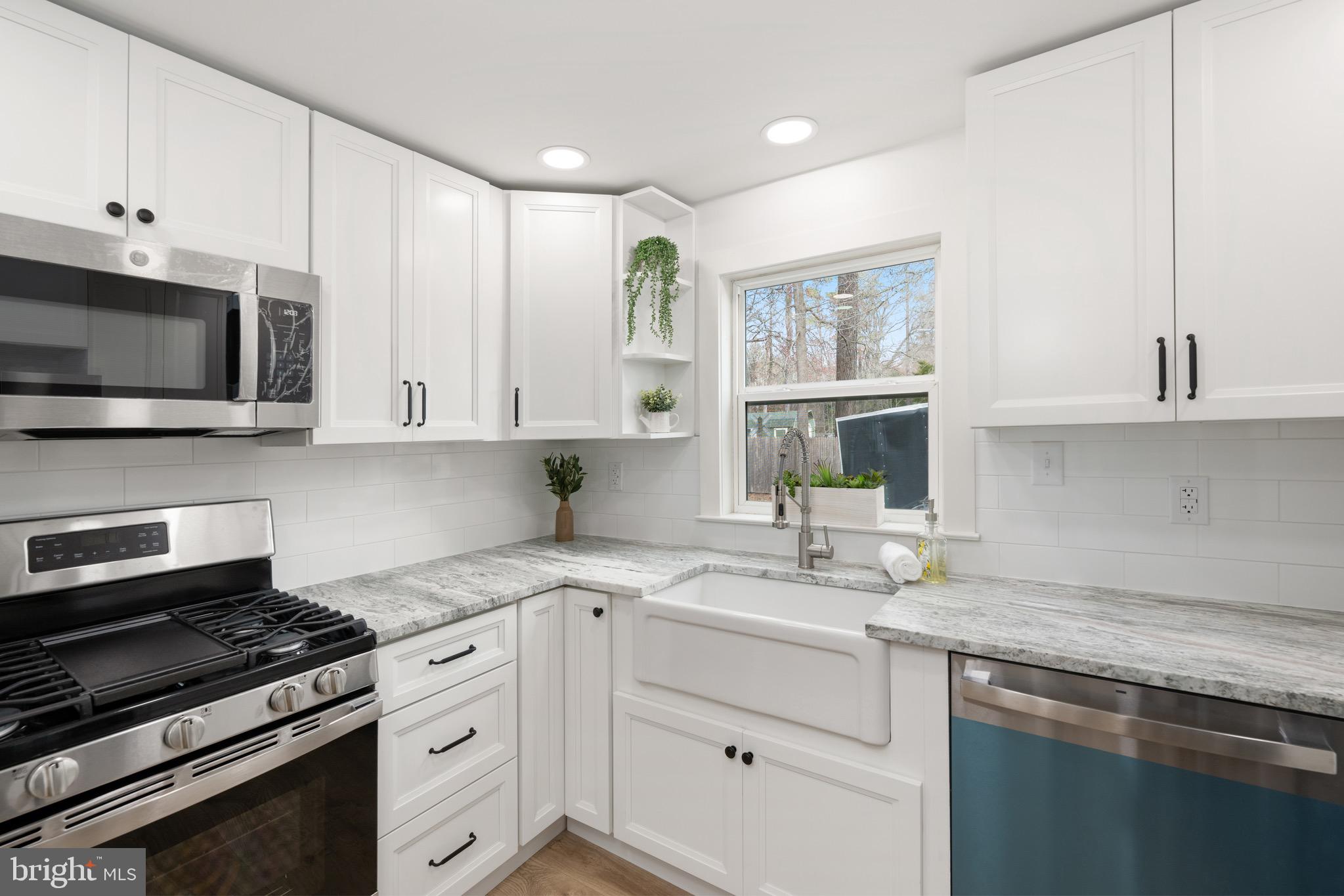 18316 Shingle Point Road Georgetown, DE 19947 - Photo 13 of 35 a kitchen with stainless steel appliances granite countertop white cabinets granite counter tops and a window