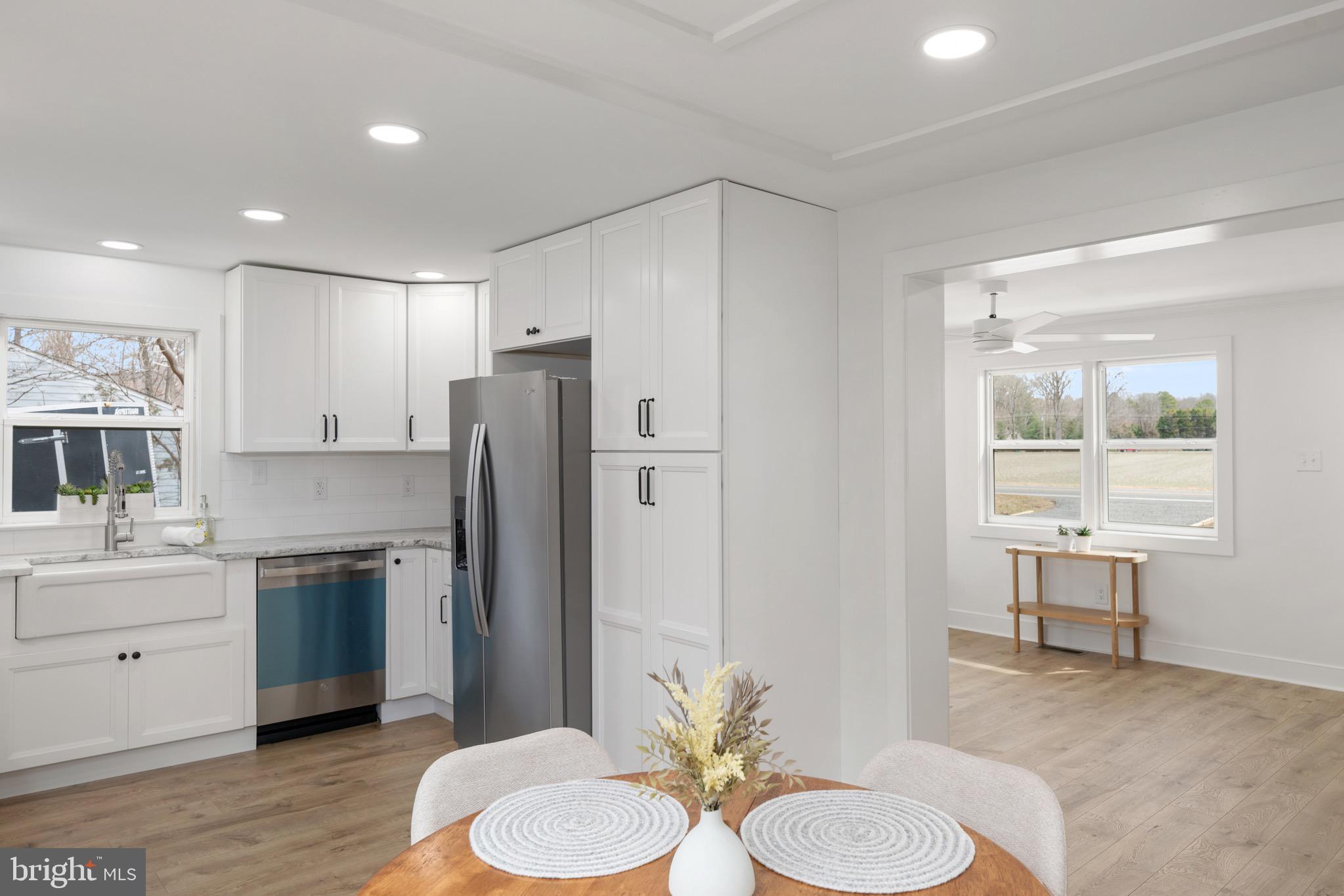18316 Shingle Point Road Georgetown, DE 19947 - Photo 16 of 35 a kitchen with stainless steel appliances a sink a refrigerator and wooden floor