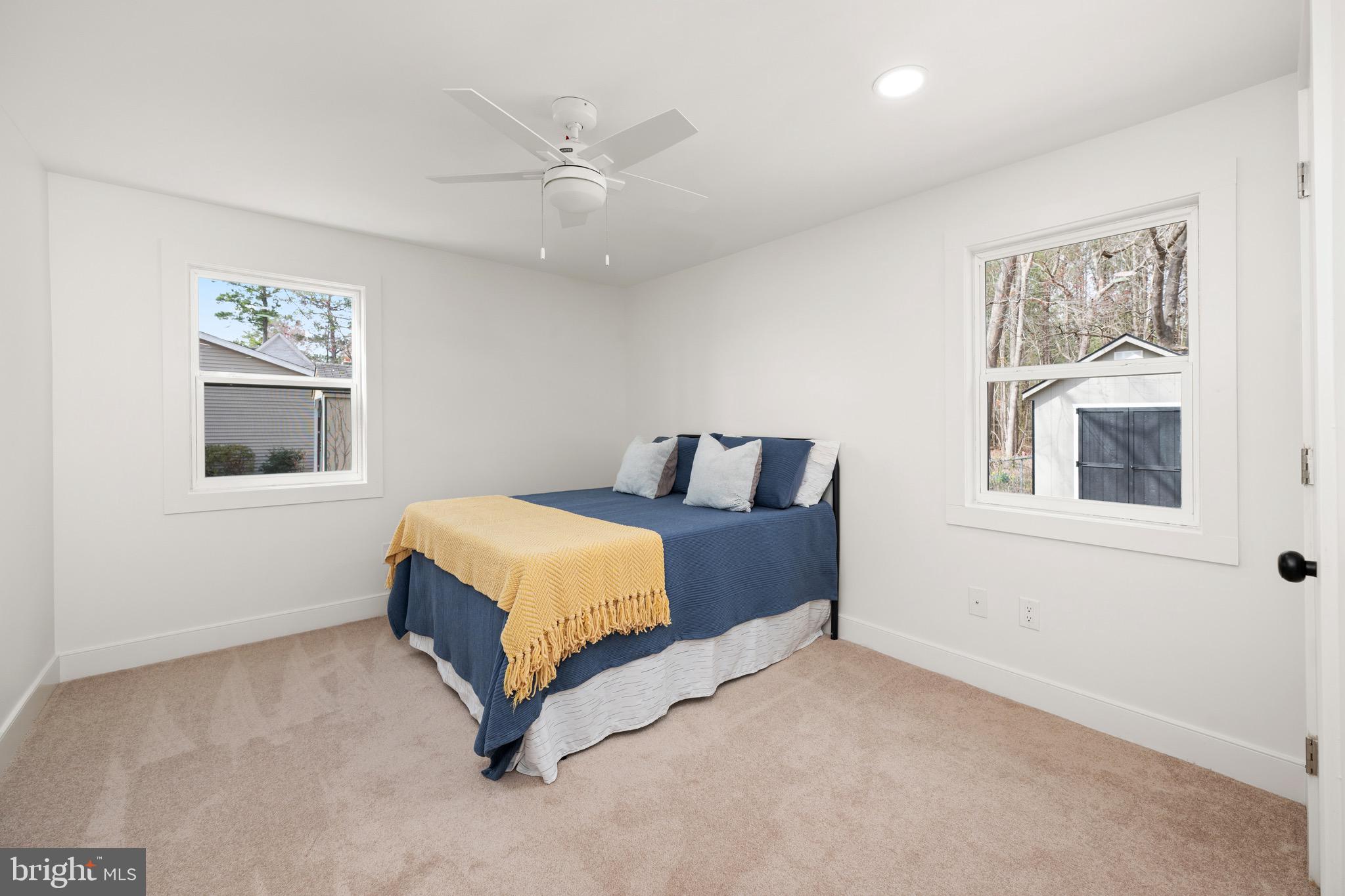 18316 Shingle Point Road Georgetown, DE 19947 - Photo 17 of 35 a bedroom with a bed lamp and paintings on the wall