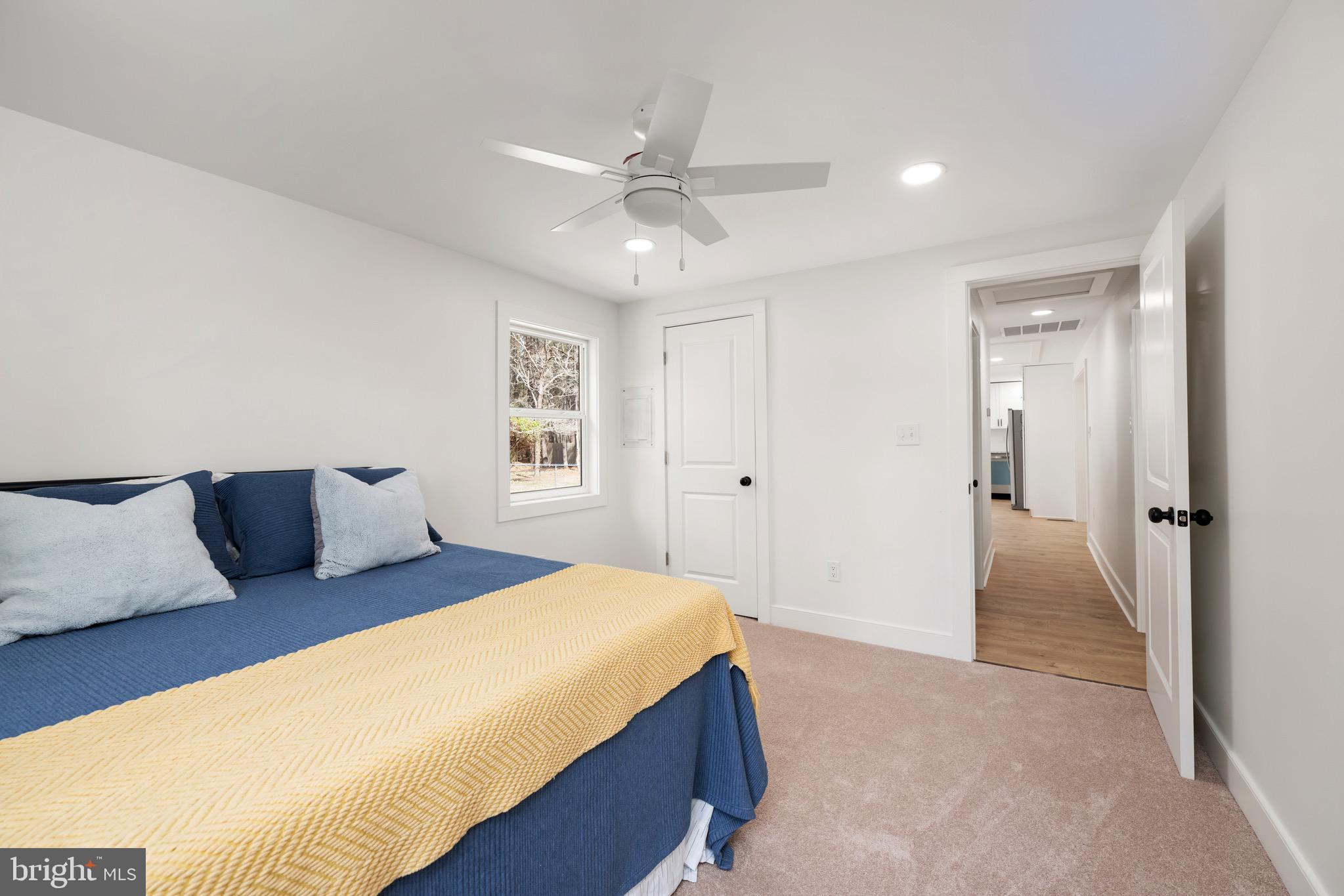 18316 Shingle Point Road Georgetown, DE 19947 - Photo 19 of 35 a bedroom with a large bed and a chandelier