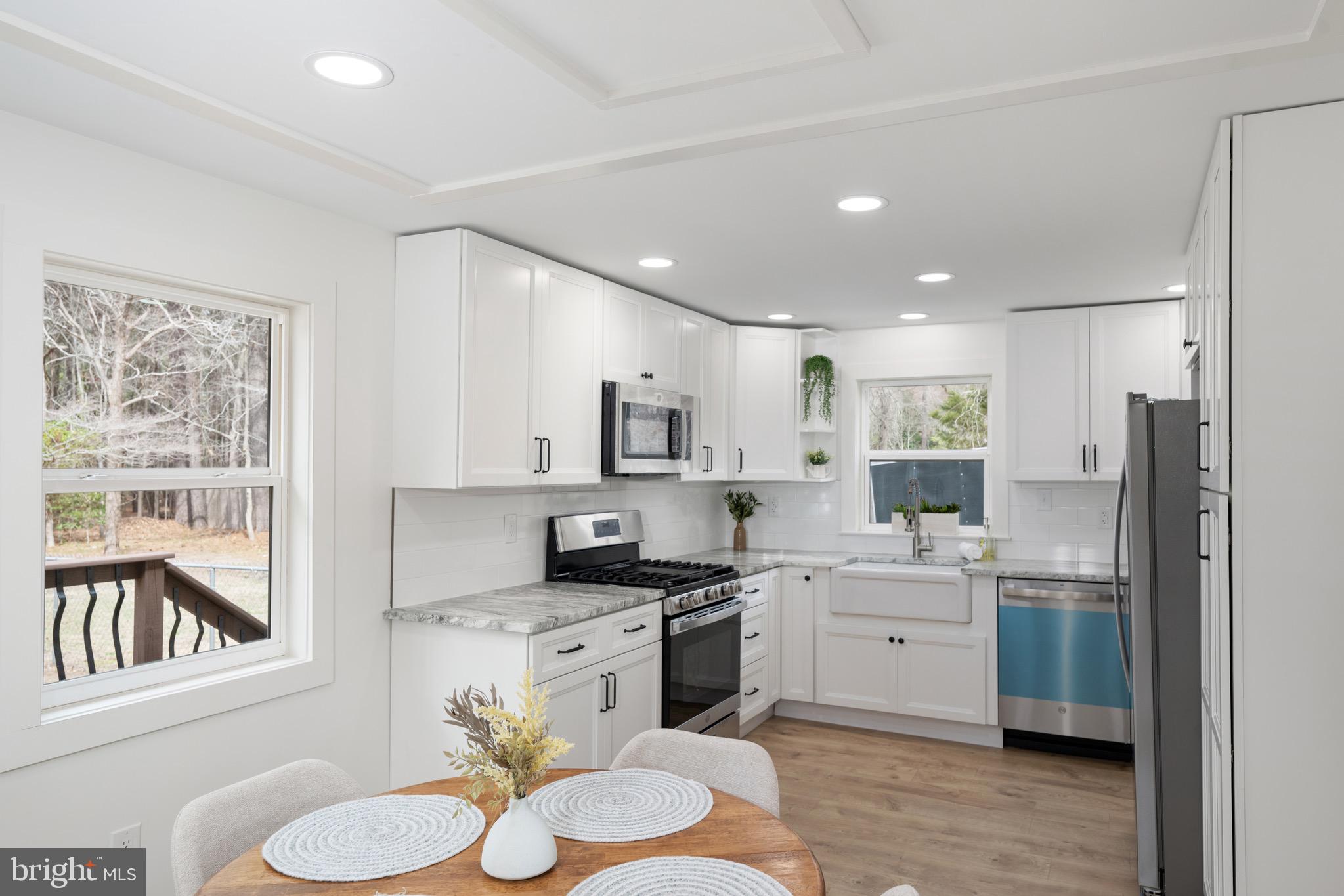 18316 Shingle Point Road Georgetown, DE 19947 - Photo 10 of 35 a kitchen with a sink white cabinets and refrigerator