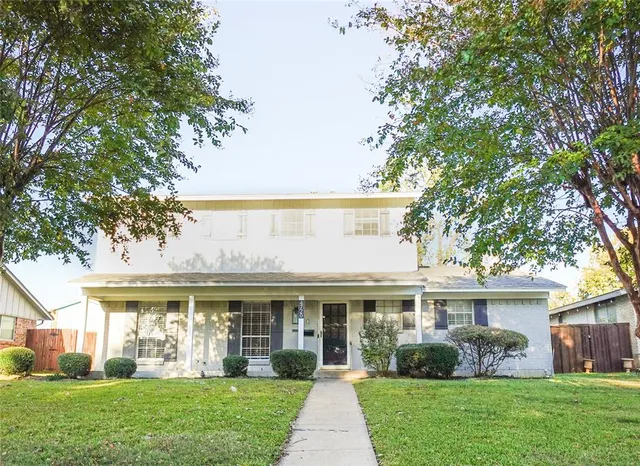 a front view of a house with a yard and garden