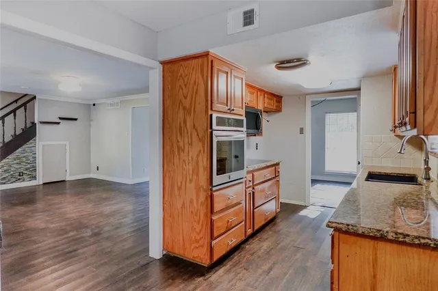 a kitchen with stainless steel appliances granite countertop a stove and a refrigerator