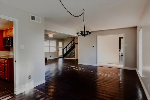 a view of a room with wooden floor staircase and a living room