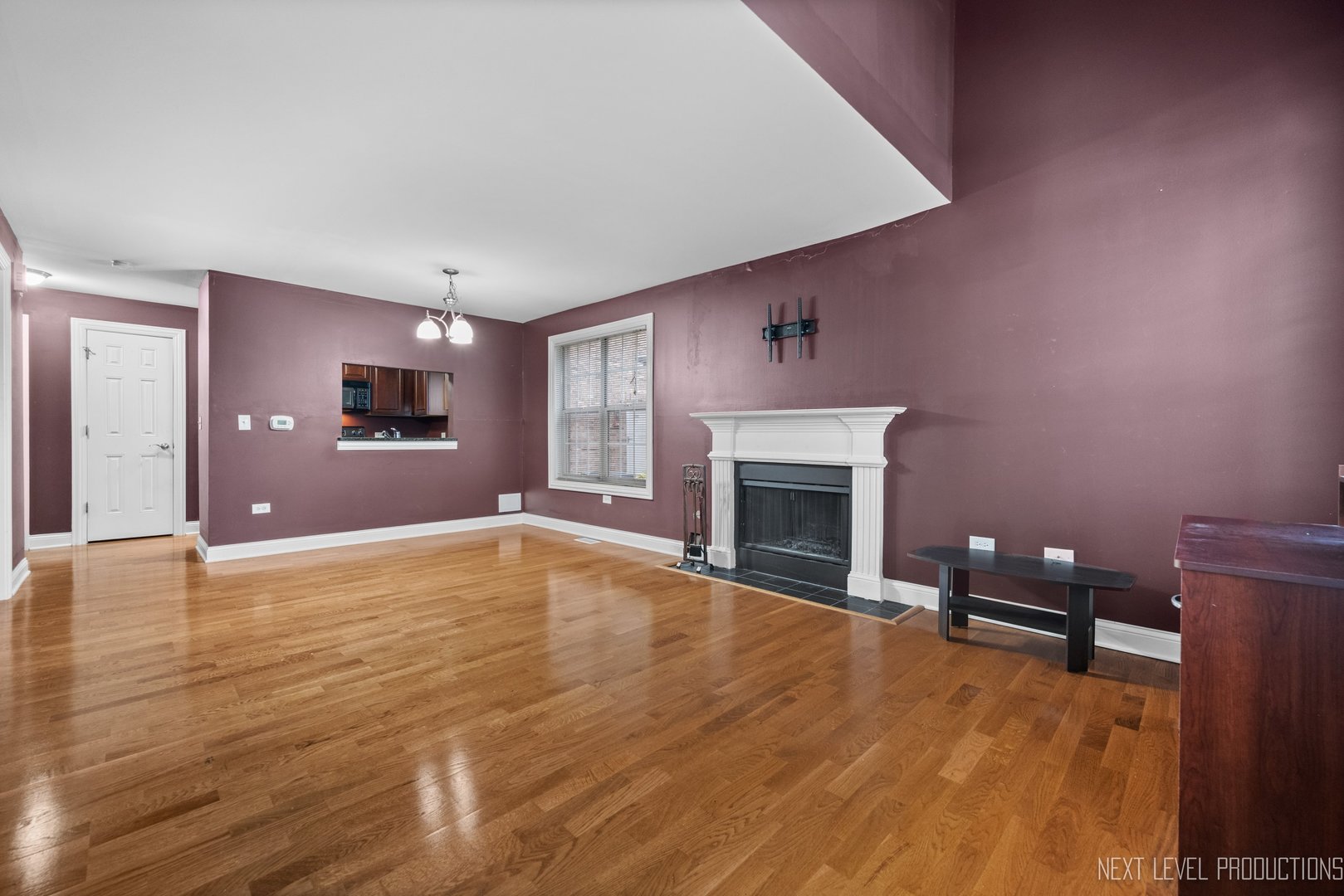 43 Foxcroft Road, Unit 119 Naperville, IL 60565 - Photo 4 of 13 a view of empty room with wooden floor and fireplace