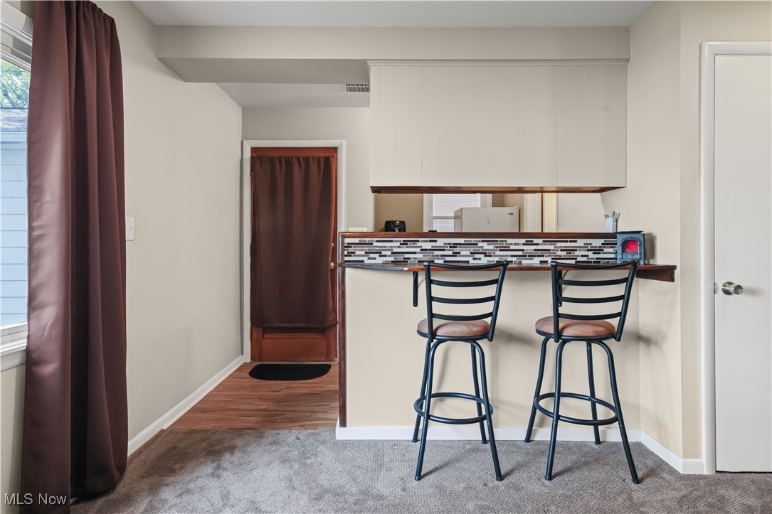 983 Roseland Road Alliance, OH 44601 - Photo 25 of 47 Kitchen with healthy amount of natural light, dark countertops, and a kitchen bar