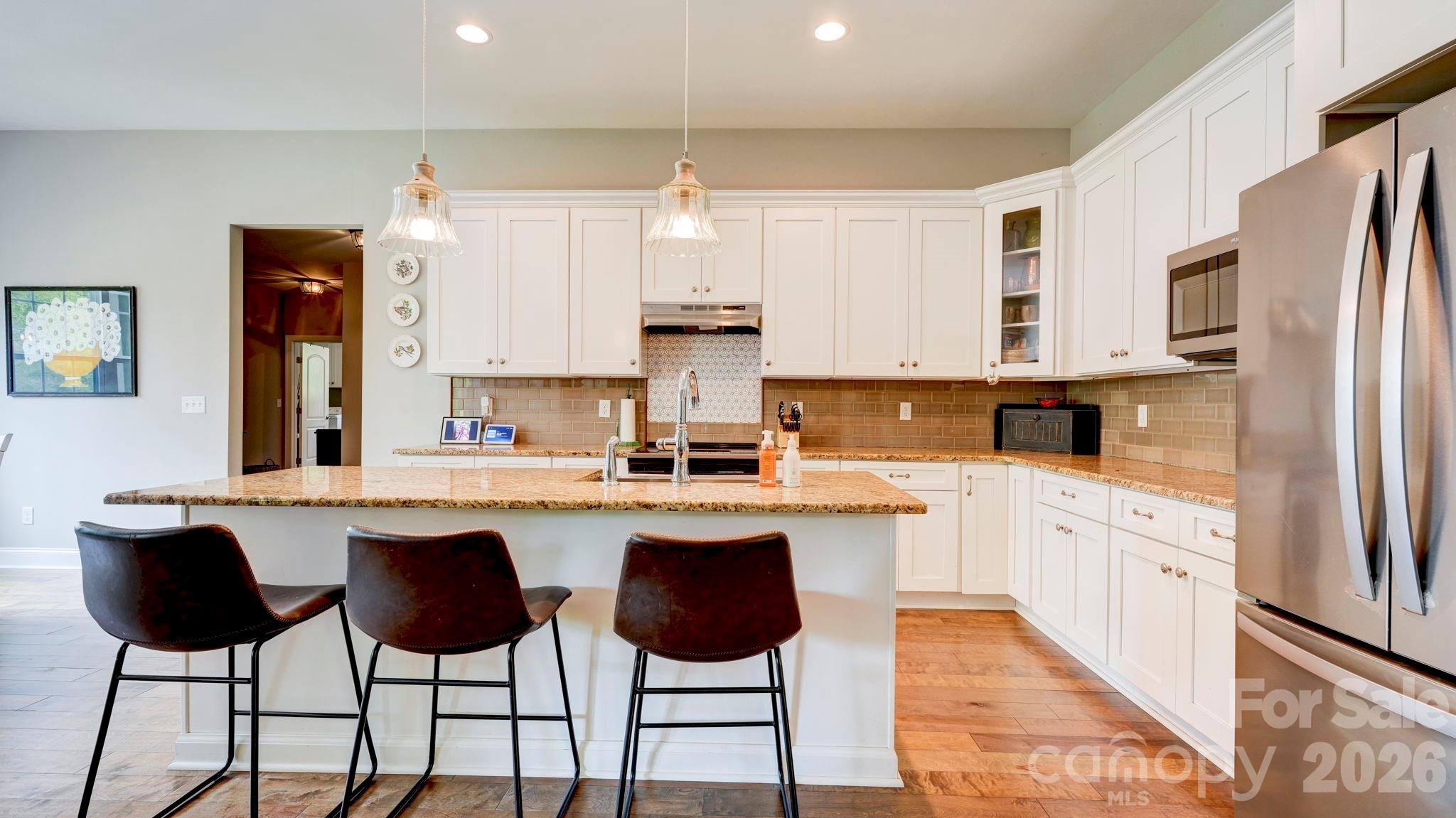 1775 Enochville Road Kannapolis, NC 28081 - Photo 17 of 41 a kitchen with stainless steel appliances granite countertop a stove top oven a sink a refrigerator and white cabinets