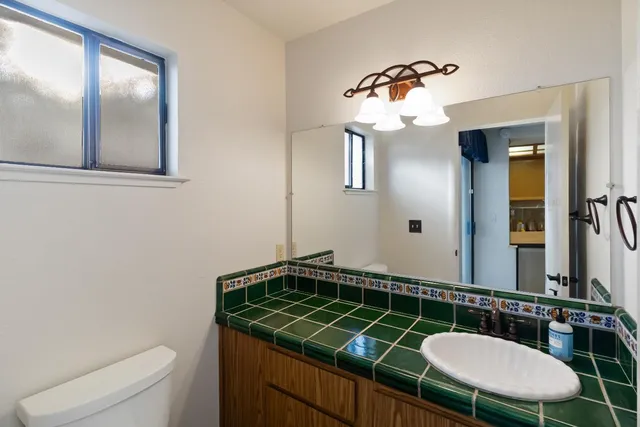 a bathroom with a sink mirror vanity and toilet
