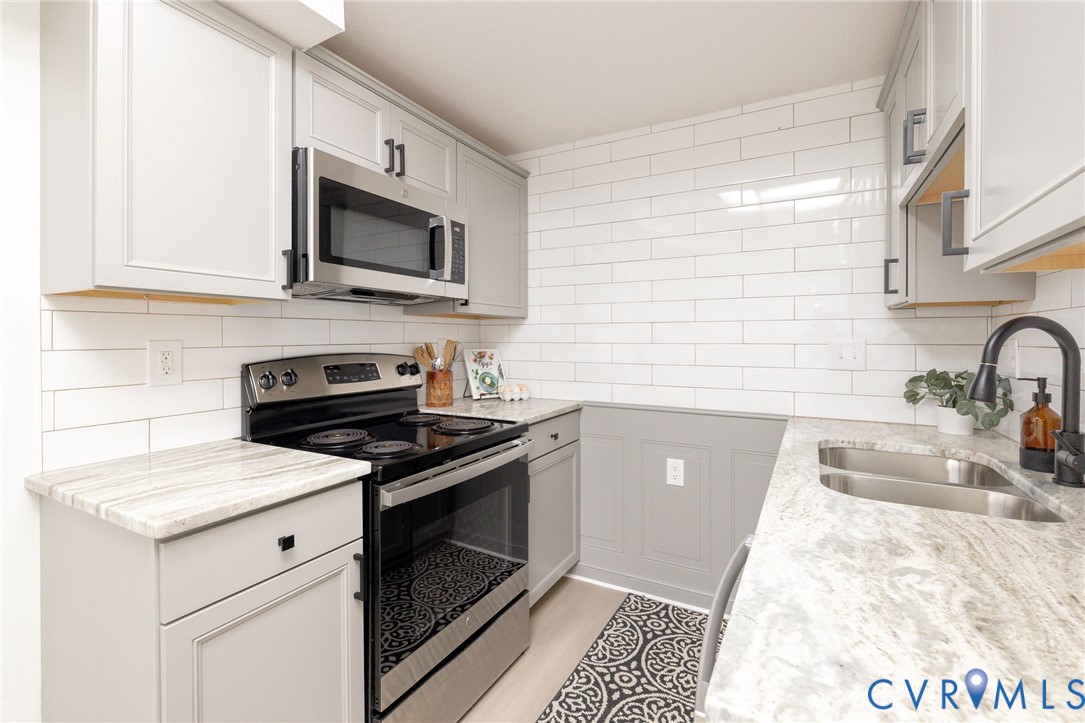 a kitchen with stainless steel appliances white cabinets granite counter tops and a sink