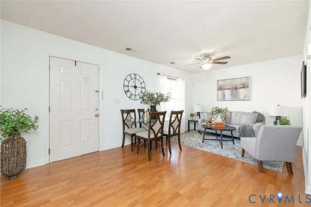 a dining room with furniture potted plants and wooden floor