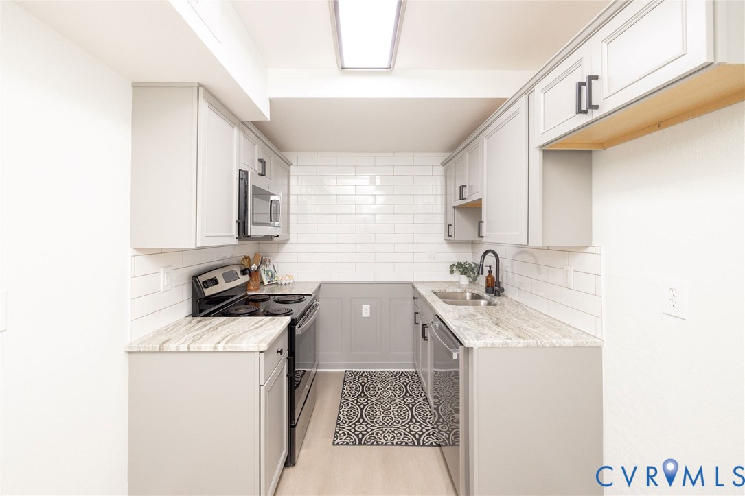 3520 East Richmond Road, Unit U106 Richmond, VA 23223 - Photo 6 of 18 a kitchen that has a sink and a stove in it