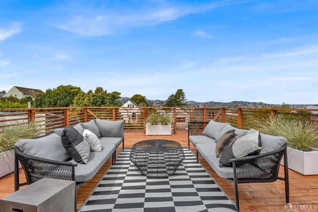 a balcony with wooden floor and outdoor seating