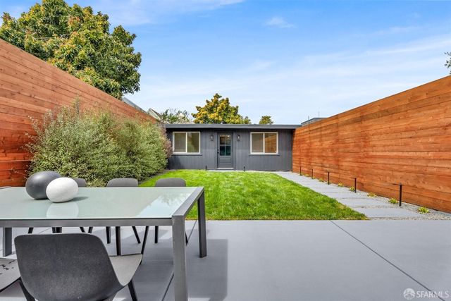 a backyard of a house with table and chairs