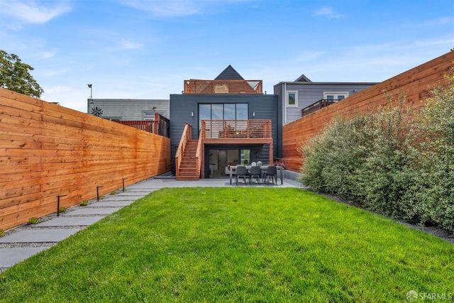 a view of a patio with table and chairs with wooden floor and fence