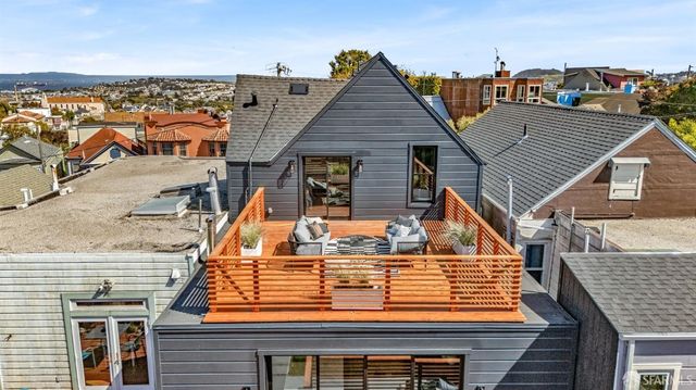 a backyard of a house with barbeque oven table and chairs
