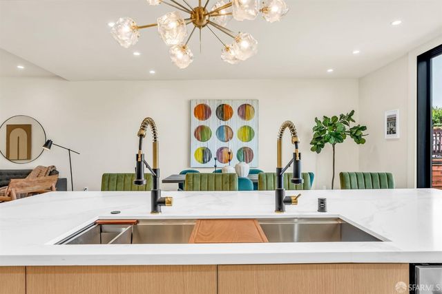 a kitchen with kitchen island a large counter top a stove and a sink