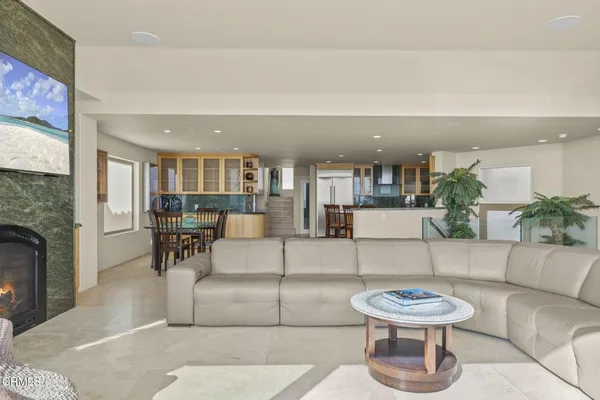 a living room with couches and a dining table with kitchen view