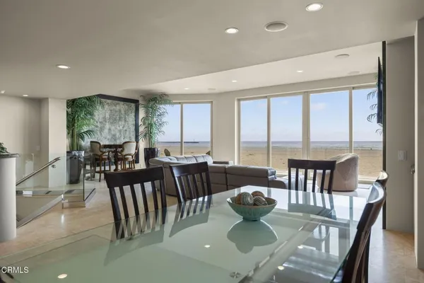 a kitchen with a dining table chairs and refrigerator