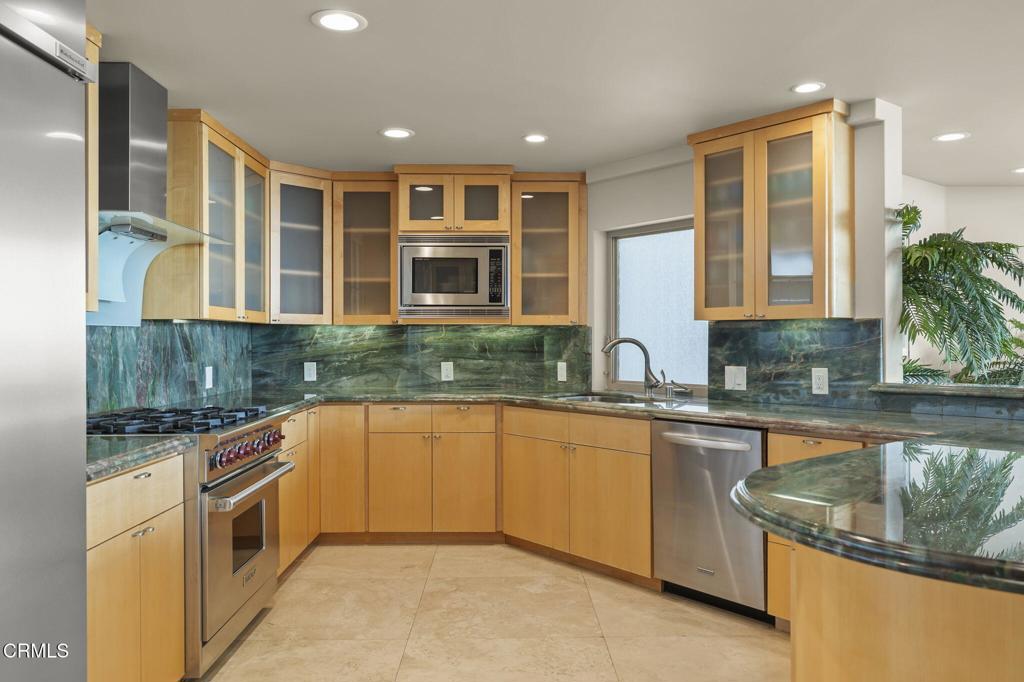 3629 Ocean Drive Oxnard, CA 93035 - Photo 23 of 60 a large kitchen with stainless steel appliances granite countertop a stove a sink and a microwave