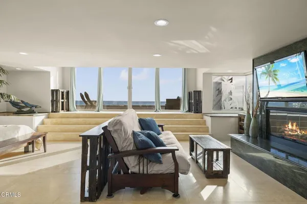 a living room with furniture a large window and a flat screen tv
