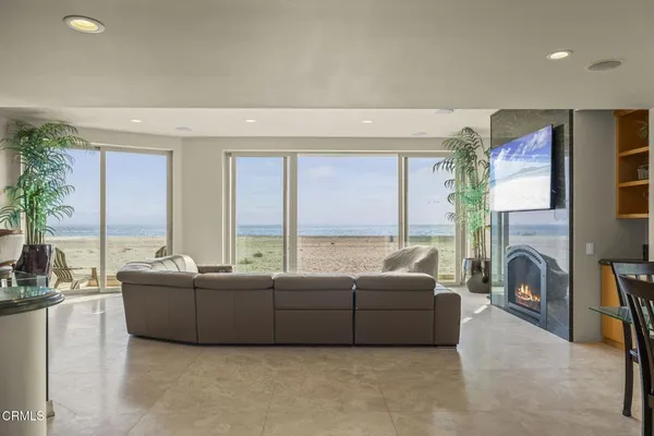 a living room with furniture a large window and a fireplace