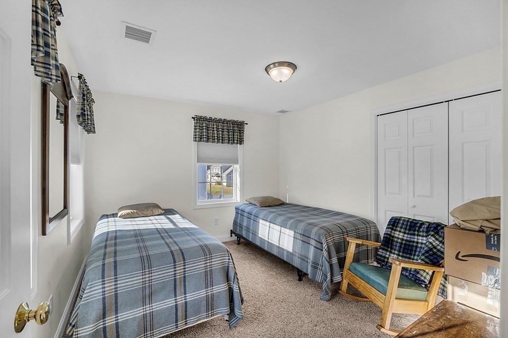 79 River Road Pepperell, MA 01463 - Photo 15 of 30 a bedroom with two beds and a lamp on the dresser