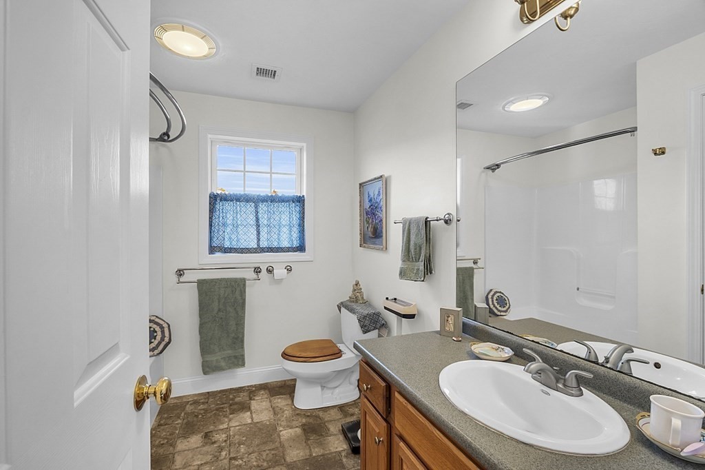 79 River Road Pepperell, MA 01463 - Photo 16 of 30 a bathroom with a sink toilet a mirror and vanity