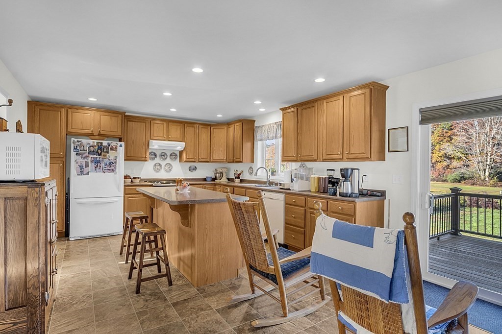 79 River Road Pepperell, MA 01463 - Photo 7 of 30 a view of kitchen with refrigerator microwave dining table and chairs