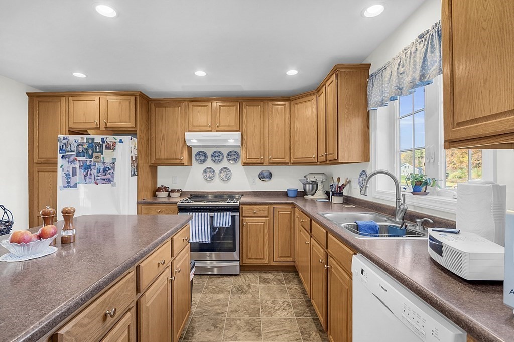 79 River Road Pepperell, MA 01463 - Photo 8 of 30 a kitchen with stainless steel appliances granite countertop sink stove top oven and cabinets