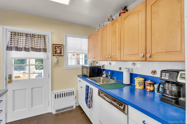 a kitchen with stainless steel appliances a sink a stove and white cabinets next to a window