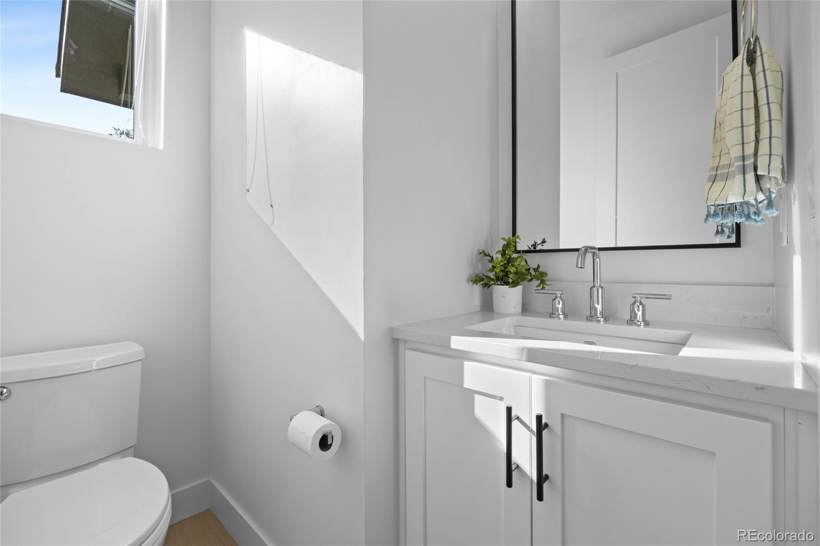 3922 Osage Street Denver, CO 80211 - Photo 18 of 44 a bathroom with a toilet sink and mirror