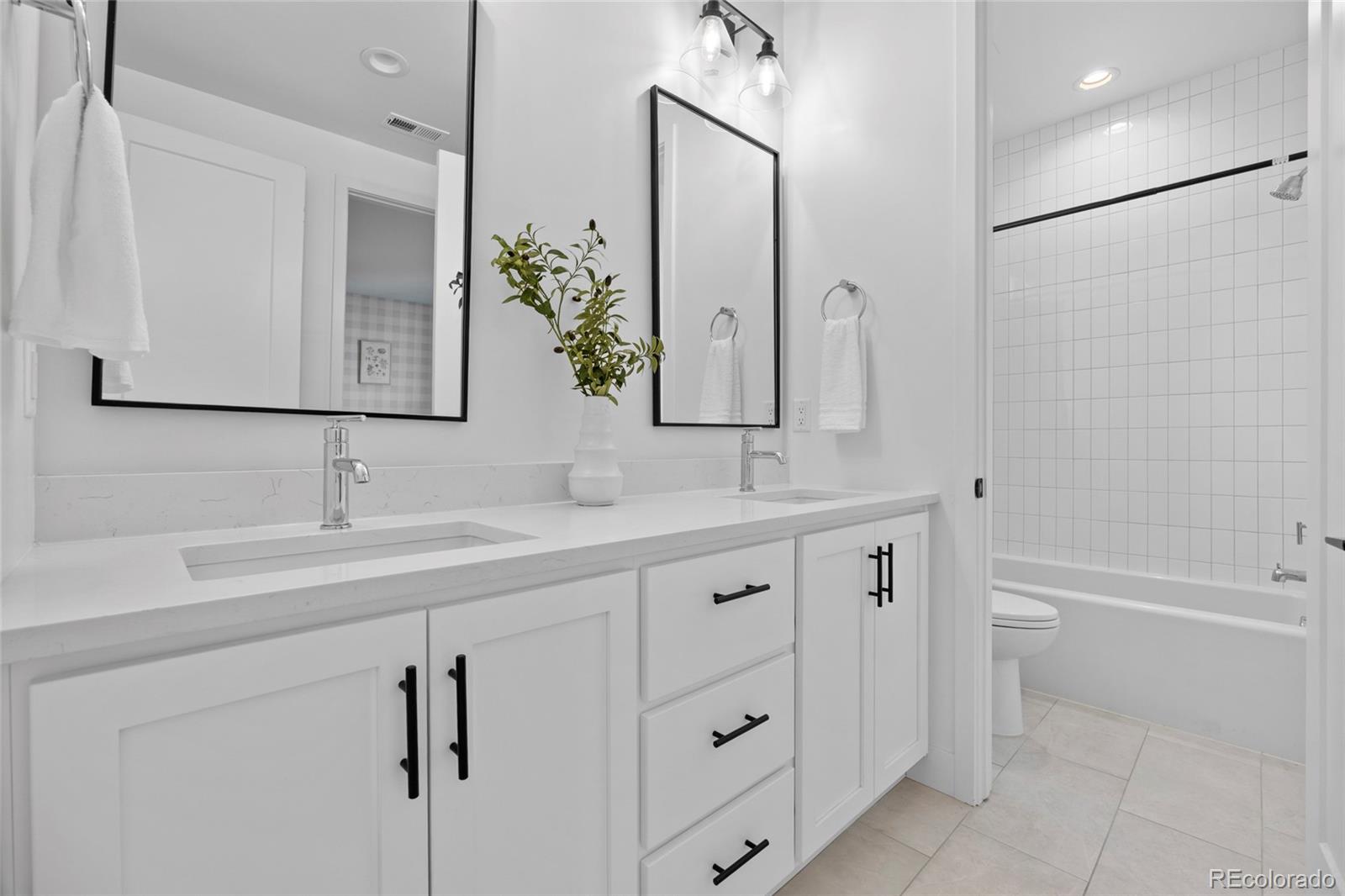 3922 Osage Street Denver, CO 80211 - Photo 26 of 44 a bathroom with a double vanity sink a mirror and a bathtub