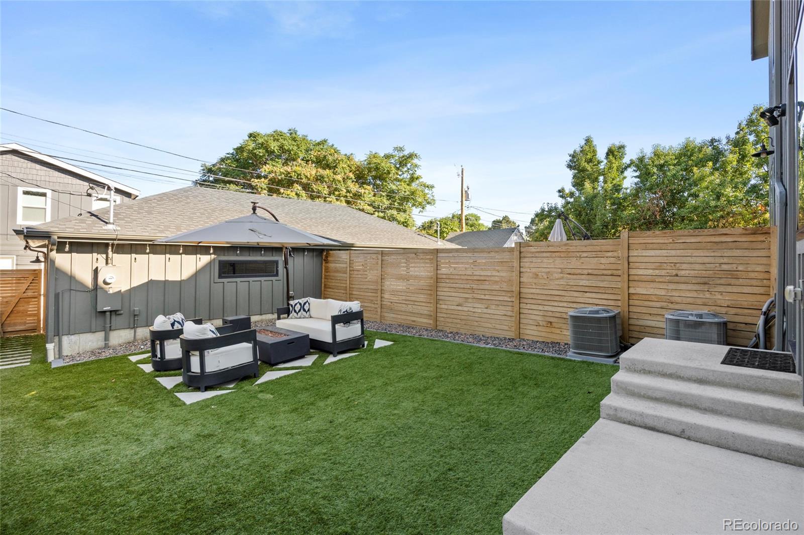 3922 Osage Street Denver, CO 80211 - Photo 34 of 44 a view of a patio with table and chairs potted plants and a palm tree