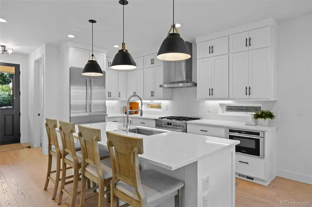 a kitchen with stainless steel appliances a stove a sink a center island and cabinets